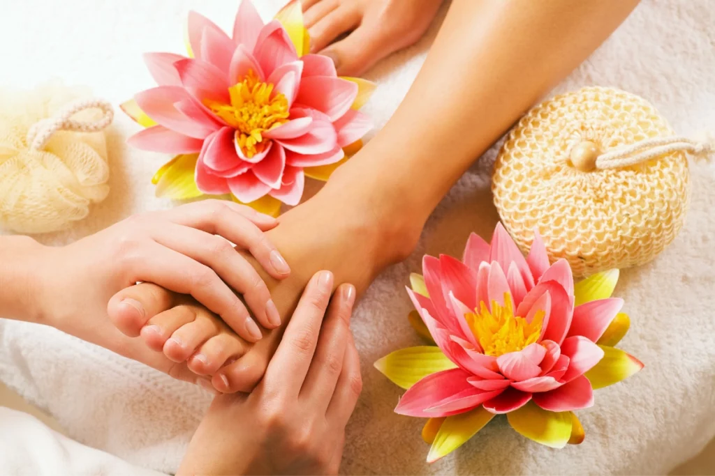 Massage des pieds avec des fleurs autour.